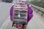 Mẹ Việt đi xe máy đèo con bằng "lồng chim" để tránh rét