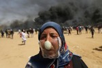 Người Palestine đeo mặt nạ hành tây đối phó với lựu đạn hơi cay của binh lính Israel